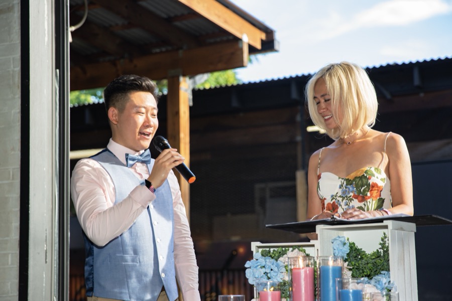 Yinja at the microphone beside Melissa